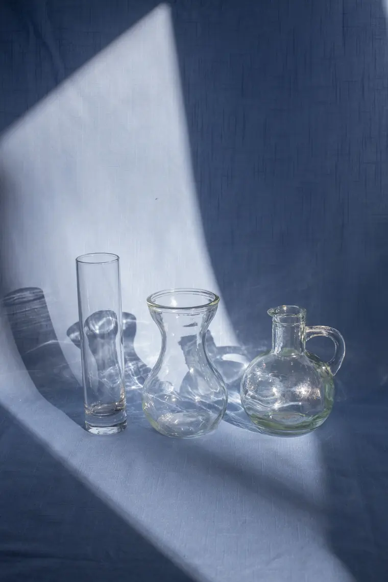 Collection of glass vases on fabric with shadows