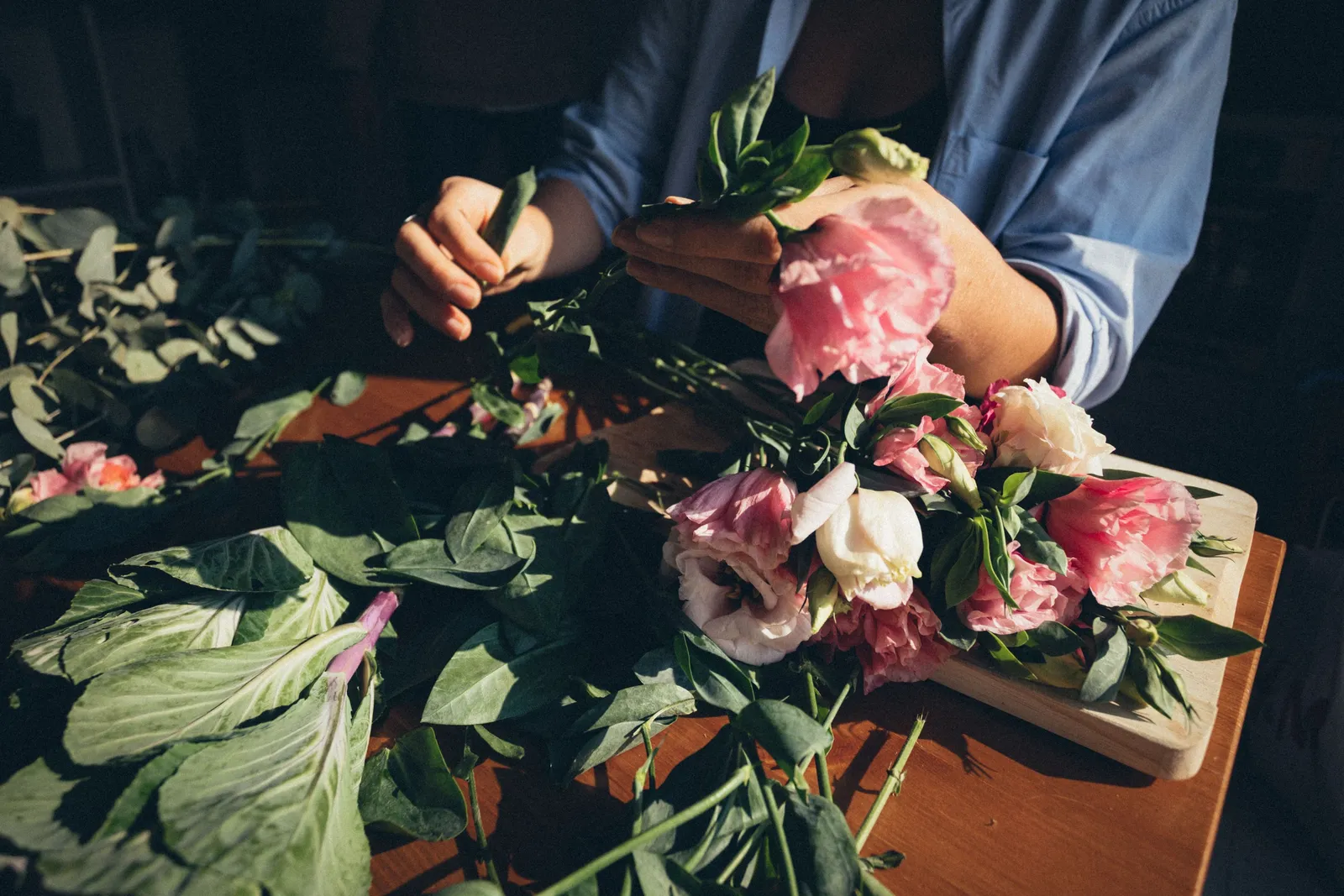 Atölye tezgâhında buket hazırlayan florist elleri — online çiçek siparişi